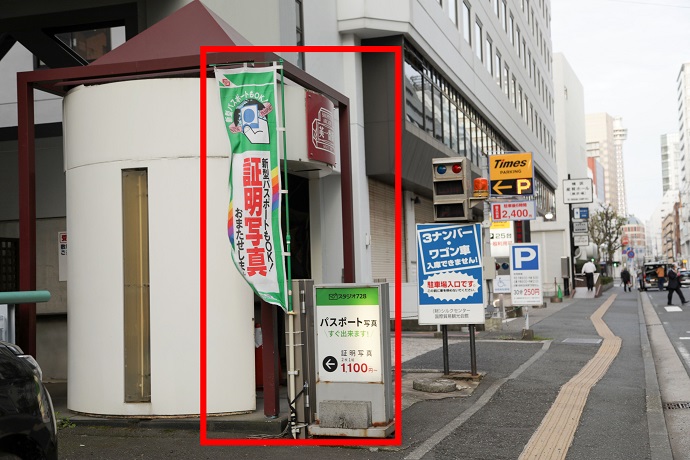 駐輪場や郵便局の前を通り過ぎると英一番街の入口が見えます。スタジオ728の看板と証明写真の旗が目印です